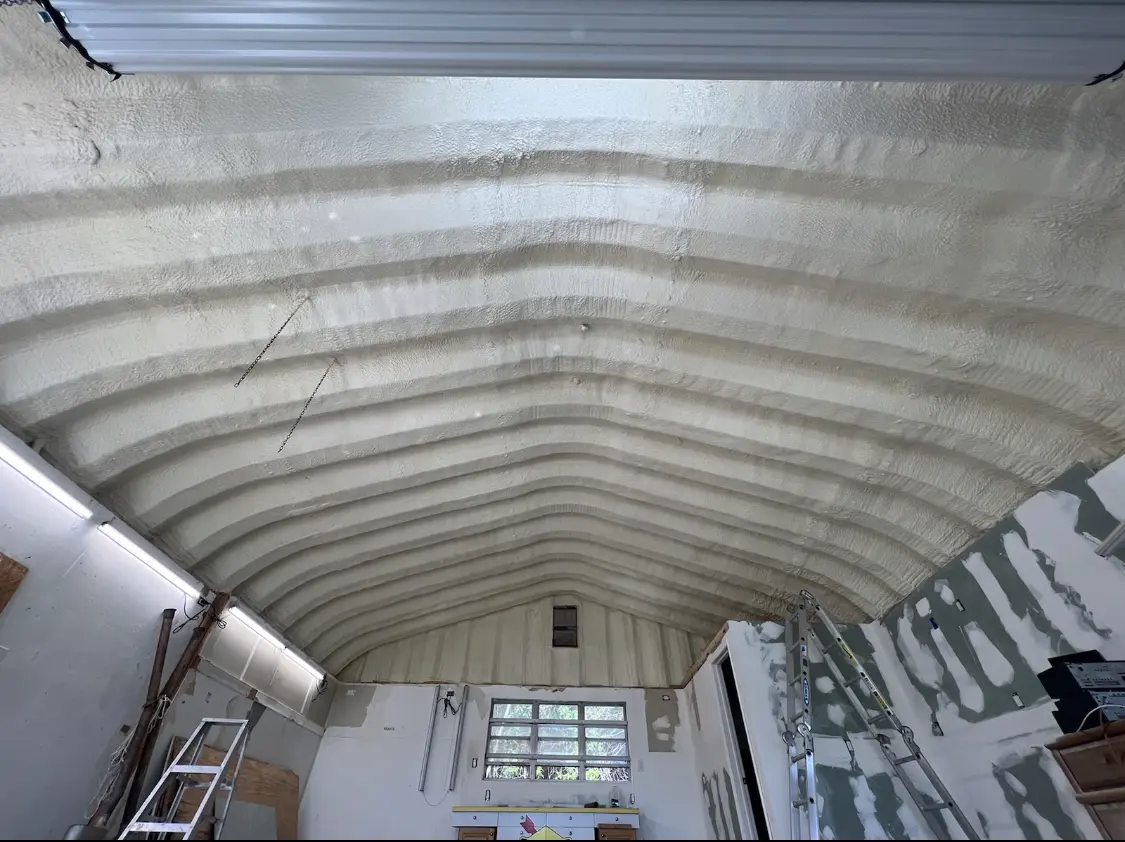 Spray polyurethane foam applied to the underside of a metal roof deck in Kirtland